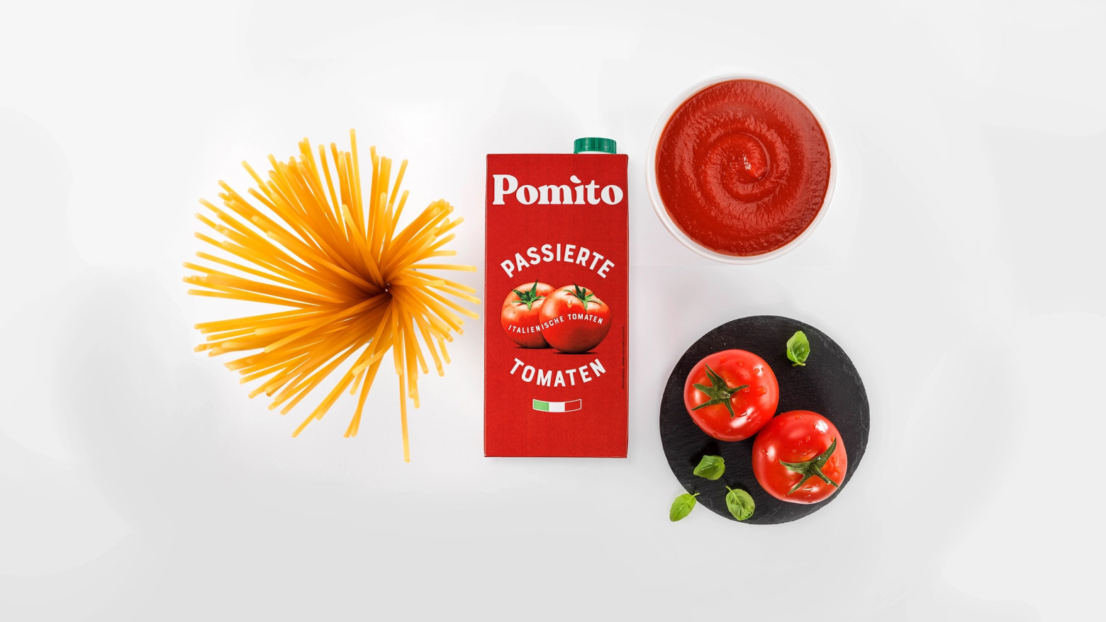 Bild von oben auf Verpackung von Pomito daneben Tomatensoße, Tomaten und Spaghetti