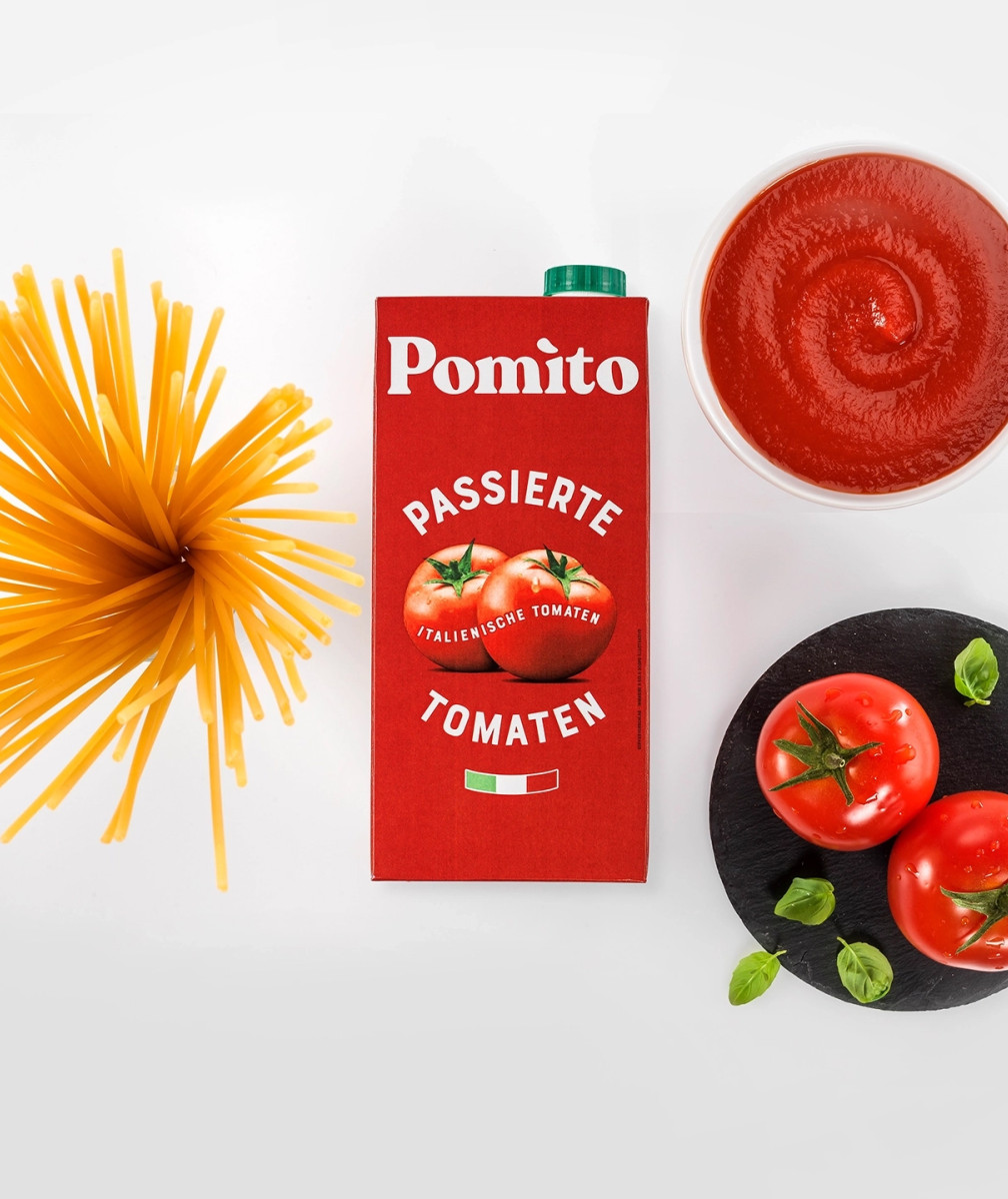 Bild von oben auf Verpackung von Pomito daneben Tomatensoße, Tomaten und Spaghetti