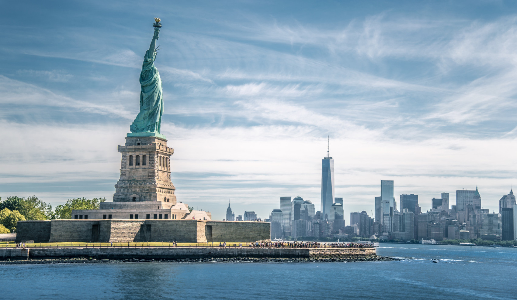 Blick auf die Freiheitsstatue in New York, im Hintergrund Skyline