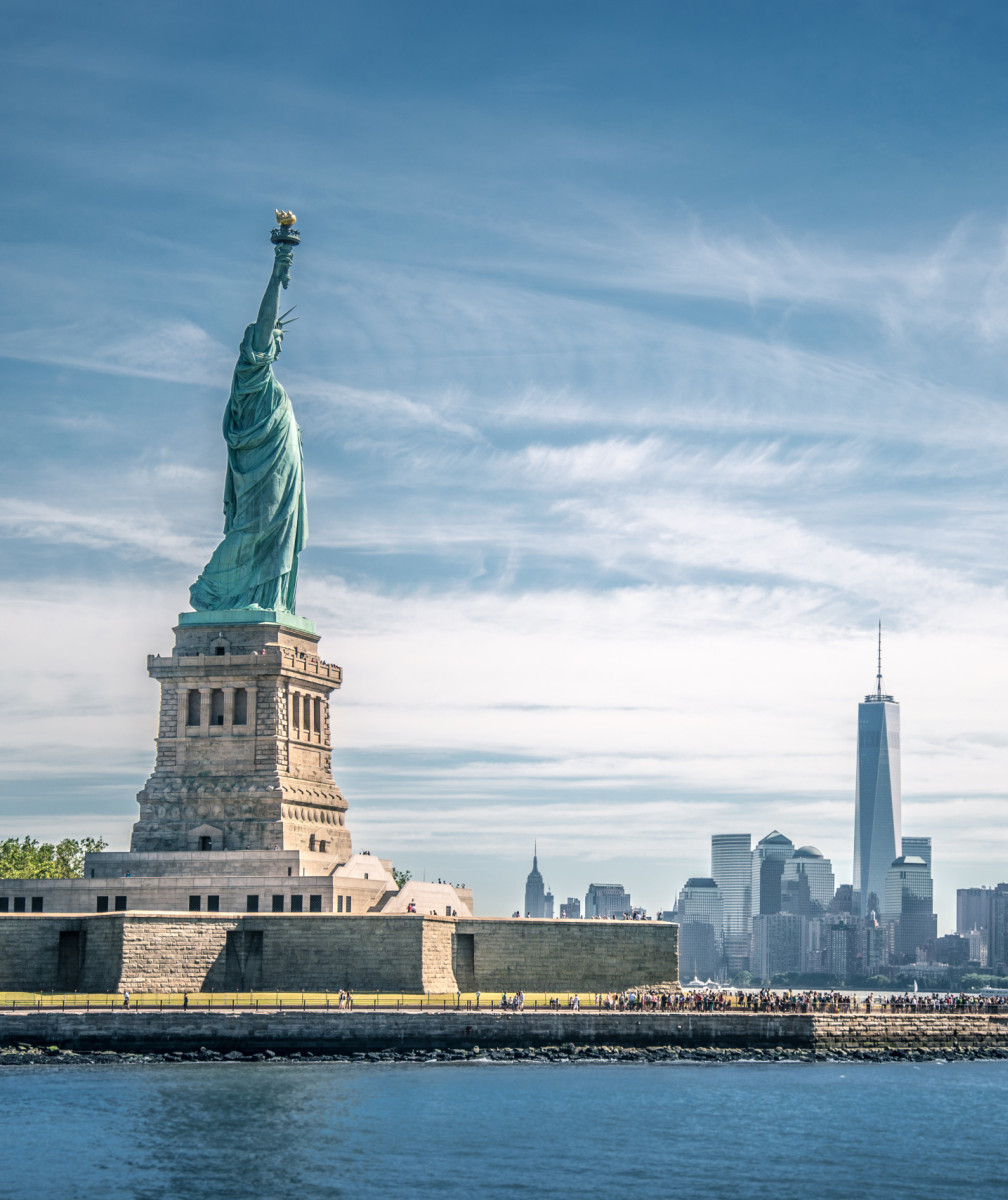 Blick auf die Freiheitsstatue in New York, im Hintergrund Skyline